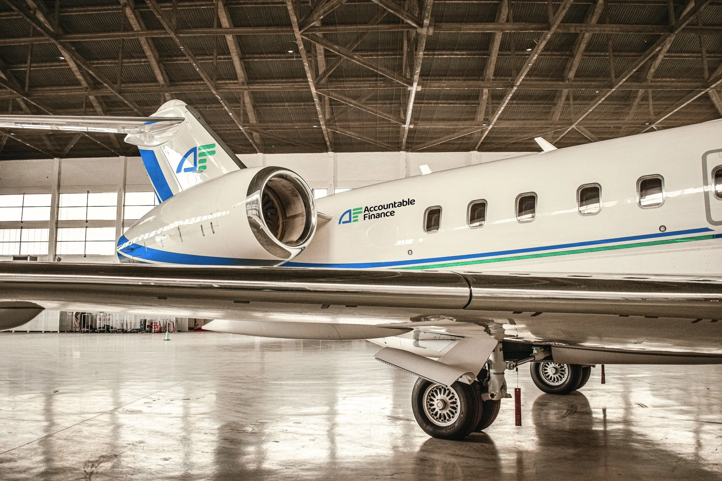 Private jet with Accountable Finance logo and muted blue and green livery stripes