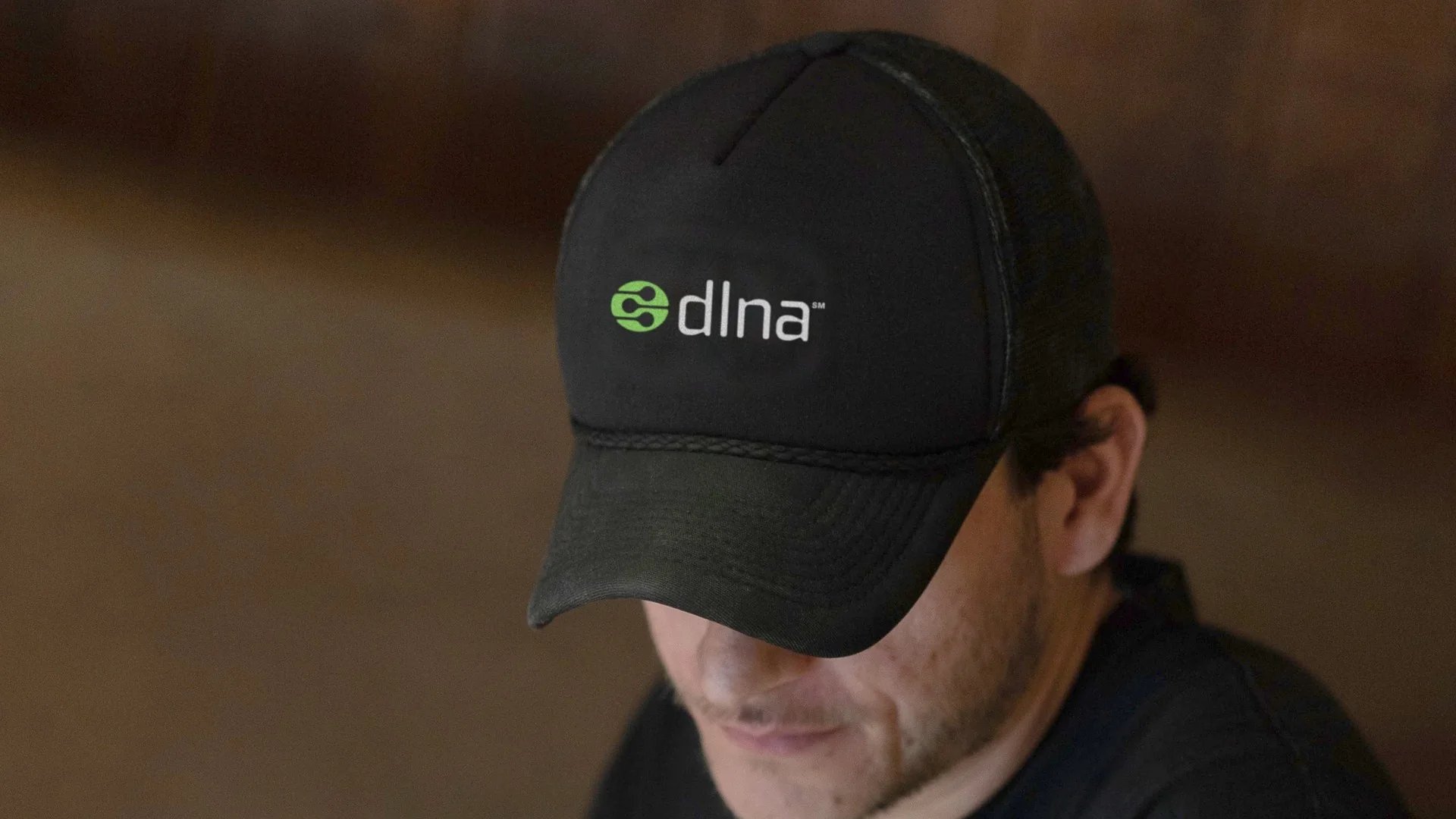 Black trucker cap with the dlna logo, green mark and white wordmark