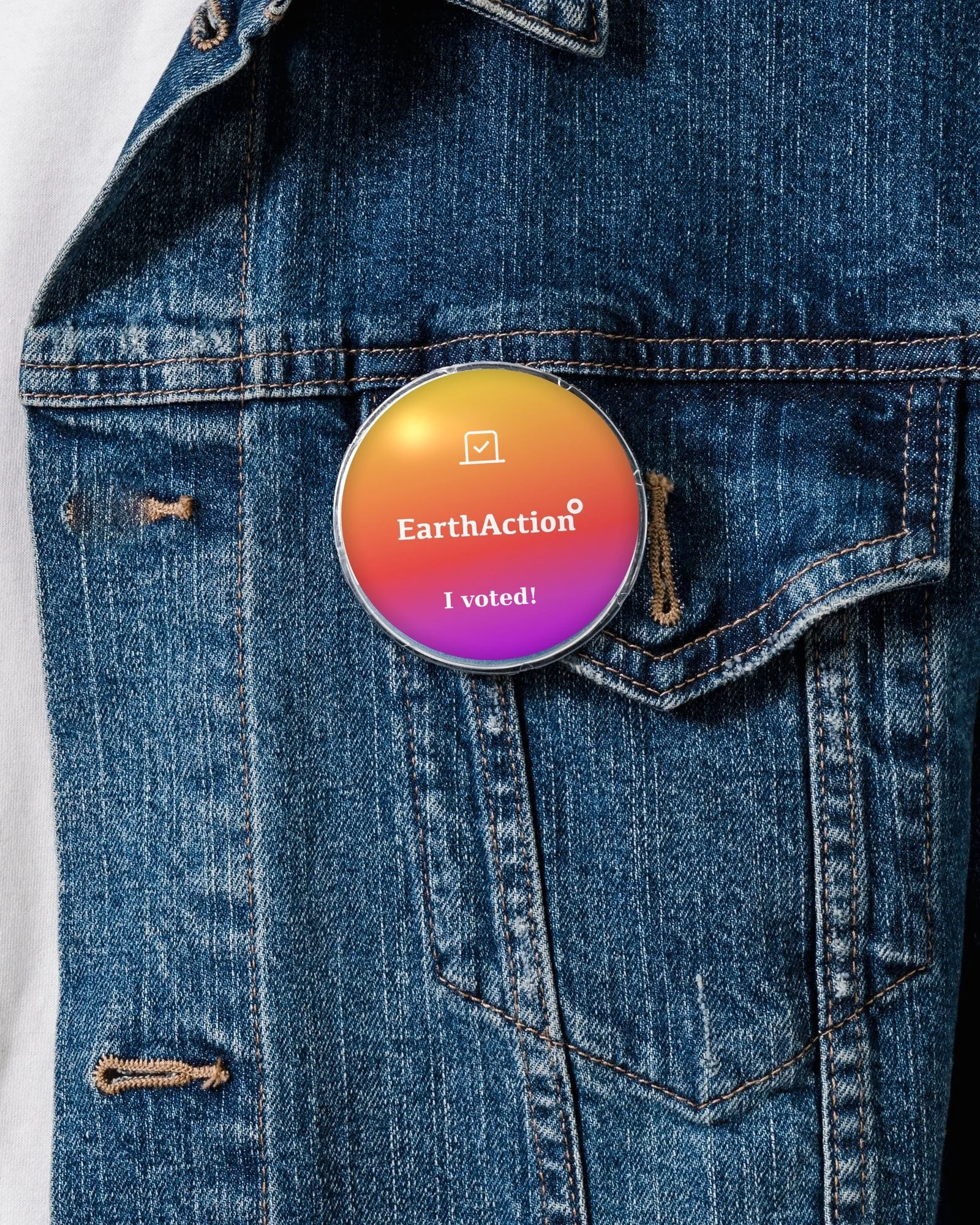 EarthAction campaign pin with the scenario gradient, a vote icon, white logo and “I voted!” on a denim jacket
