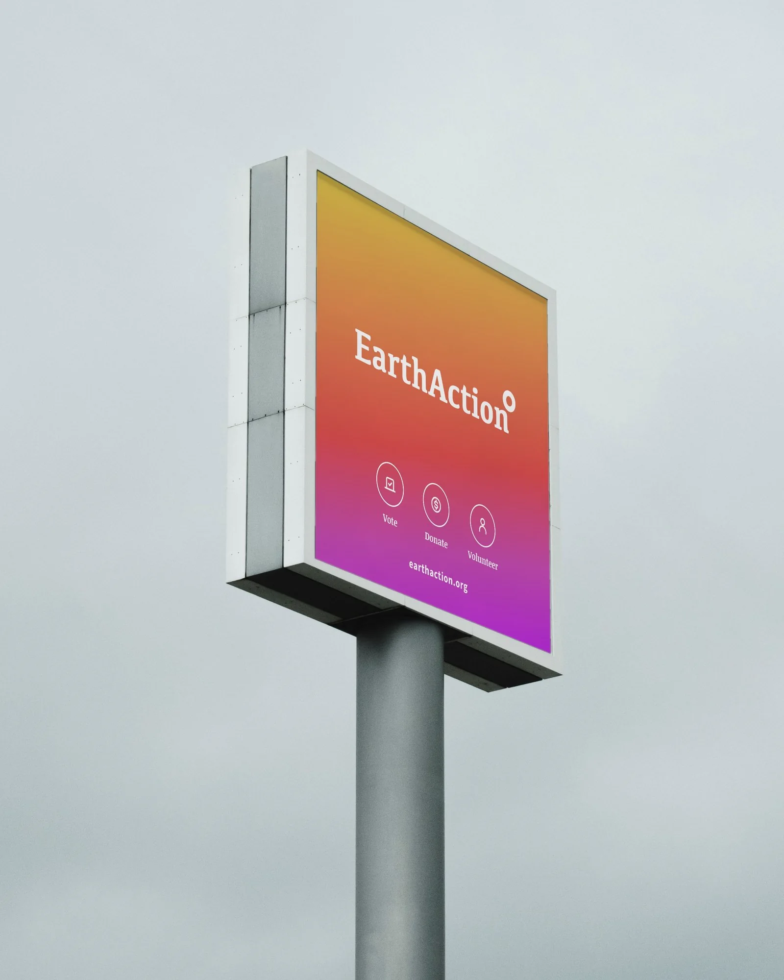 EarthAction pole sign against an overcast sky with the scenario gradient, white logo, Vote, Donate and Volunteer icons and earthaction.org
