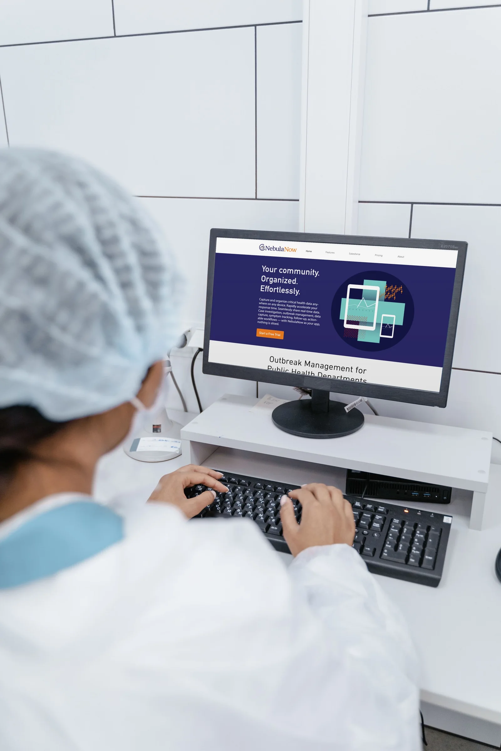 Lab technician at a desktop monitor showing the Nebula Now landing page